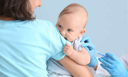 Infant held by a parent while a provider gives a vaccine in the upper arm Infant held by a parent while a provider gives a vaccine in the upper arm
