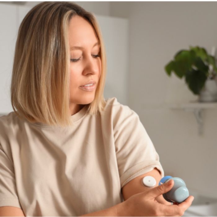 woman-applying-continuous-glucose-monitor-arm